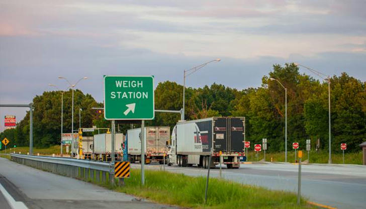 What is the main purpose of weigh stations located along highways?